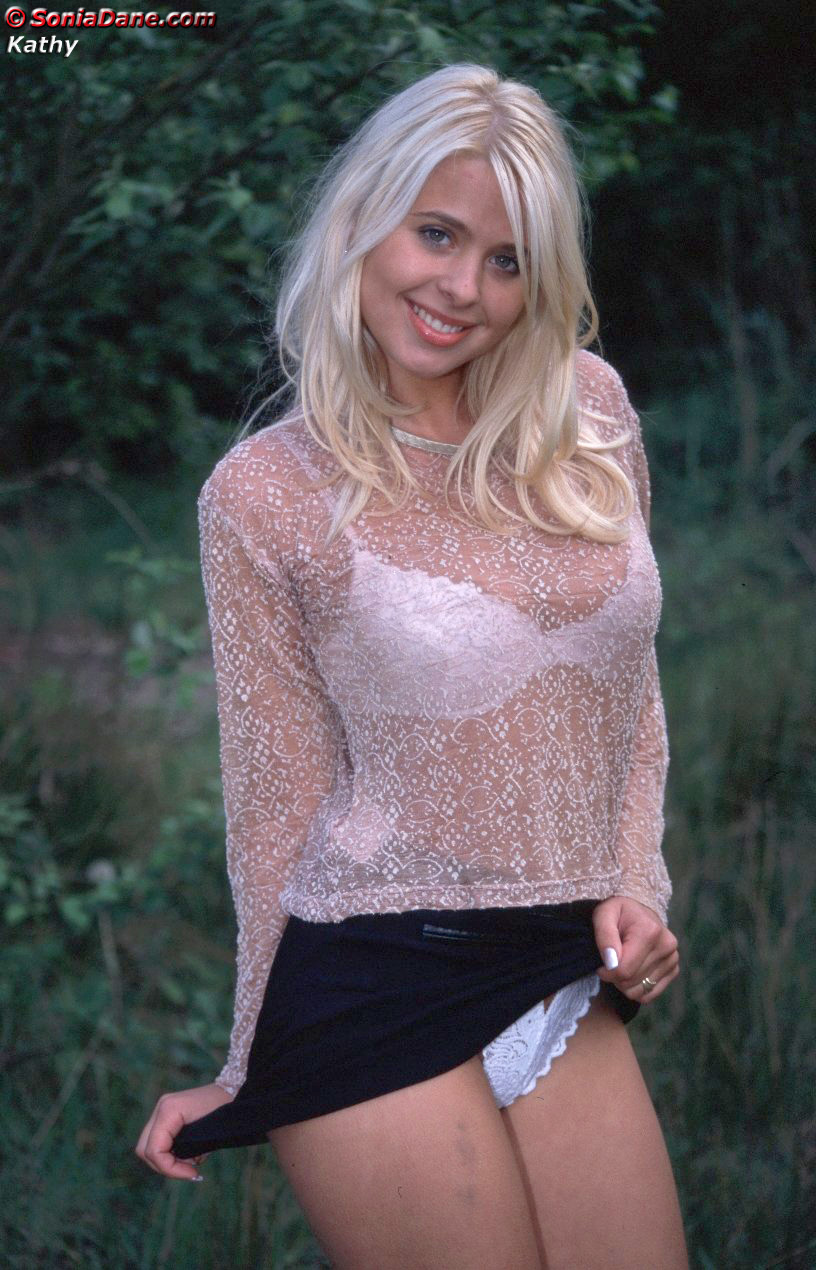 blonde lifting her skirt and showing her white panties outdoors